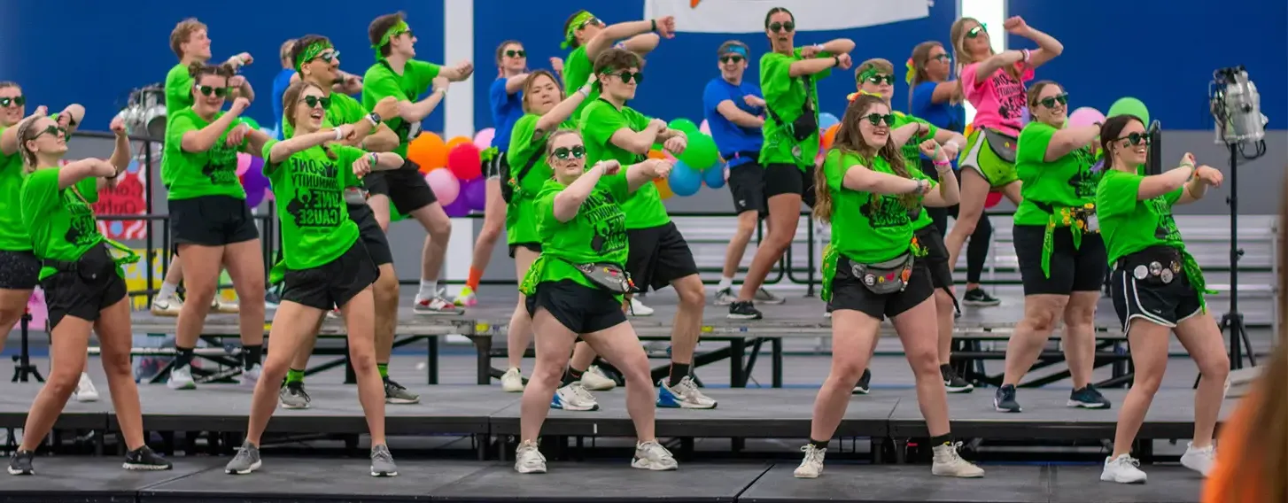 A group of students dancing on a stage for the big Dance Marathon event